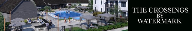 The Crossings by Watermark community pool and lounging area with people swimming and relaxing.