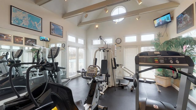 Fitness center with cardio machines, weight machines, and mirrors.