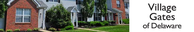 Exterior view of Village Gates of Delaware apartment buildings with brick and siding exteriors and manicured landscaping.