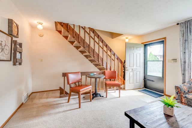 Living room with stairs and a front door.