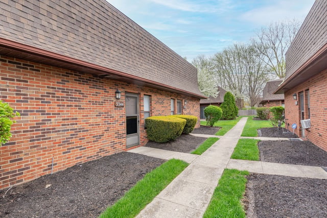 Apartment building exteriors with manicured landscaping and a walkway.