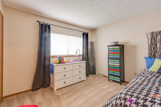 Bedroom with a dresser, window, and a bed.