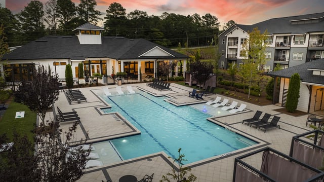 Resort-style swimming pool with lounge chairs and cabanas, next to the community clubhouse.