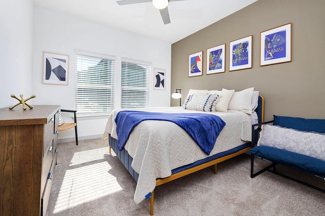 Cozy bedroom with a queen-size bed, dresser, and artwork.