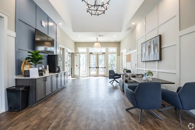 Community lounge area with coffee bar, seating, and modern decor.