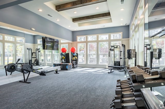 Fitness center with rowing machine, dumbbells, and weight machines.