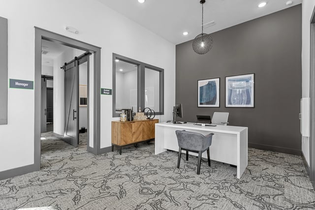 Leasing office desk with computer and chair.
