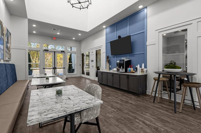 Communal coffee bar and seating area in apartment building lobby.