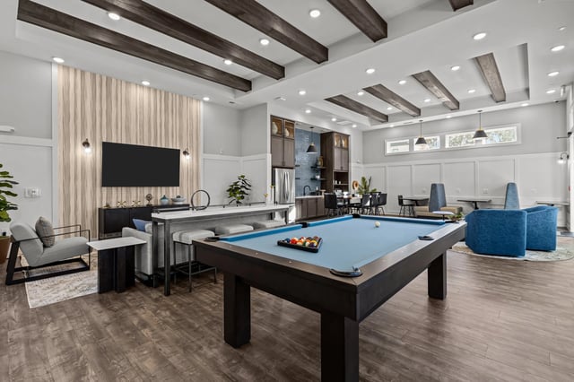 Community lounge with pool table, seating areas, and kitchen.