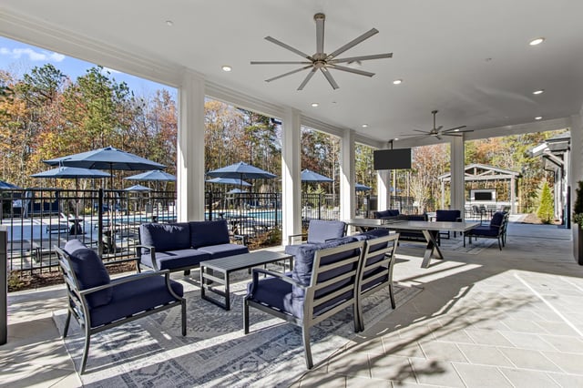 Covered outdoor lounge area with seating and pool views.