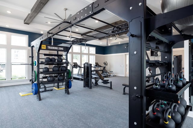 Fitness center with weight racks, treadmills, and exercise machines.