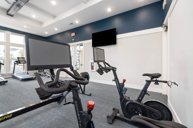 Indoor gym with cardio equipment including treadmills, rowing machine, and stationary bikes.