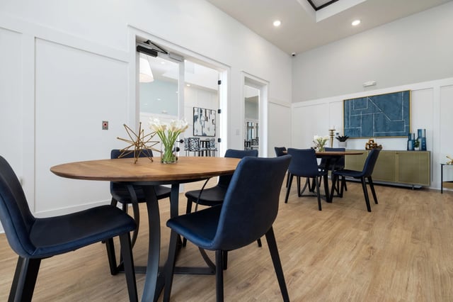 Community dining area with wooden tables and blue chairs.