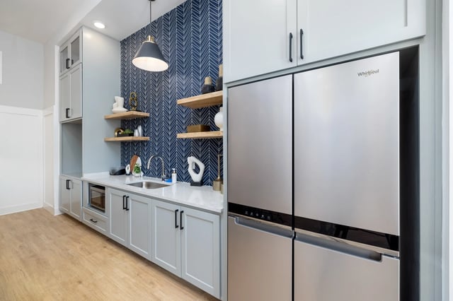 Modern kitchen with stainless steel refrigerator, microwave, and sink.