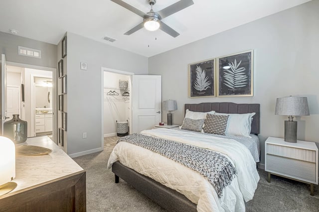 Bedroom with a king-size bed, nightstand, closet, and ensuite bathroom visible.