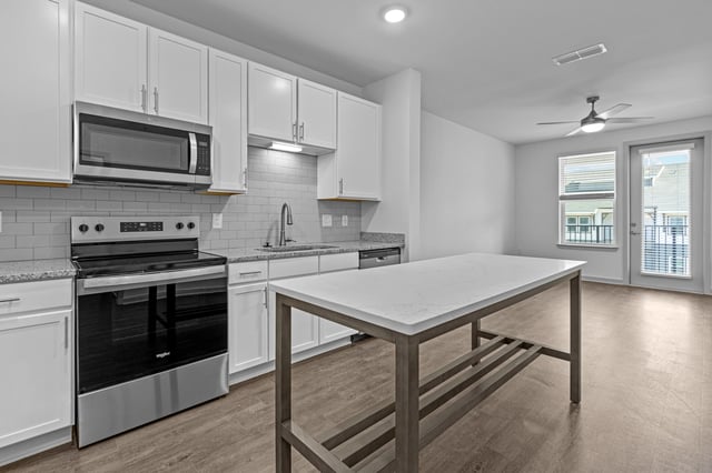 Modern kitchen with white cabinets, stainless steel appliances, and an island.