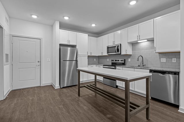 Modern kitchen with stainless steel appliances and white cabinets.