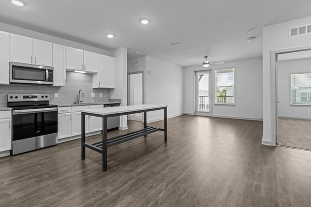 Modern kitchen and living area with an island and balcony access.