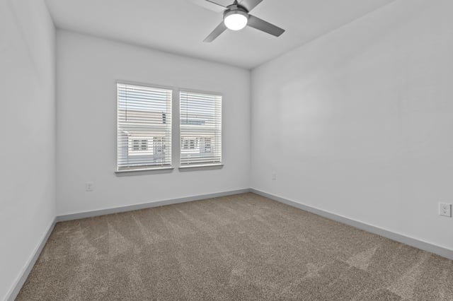 Empty bedroom with a ceiling fan and two windows.