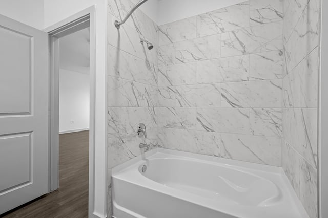 Modern bathroom with a marble-tiled shower and a white bathtub.