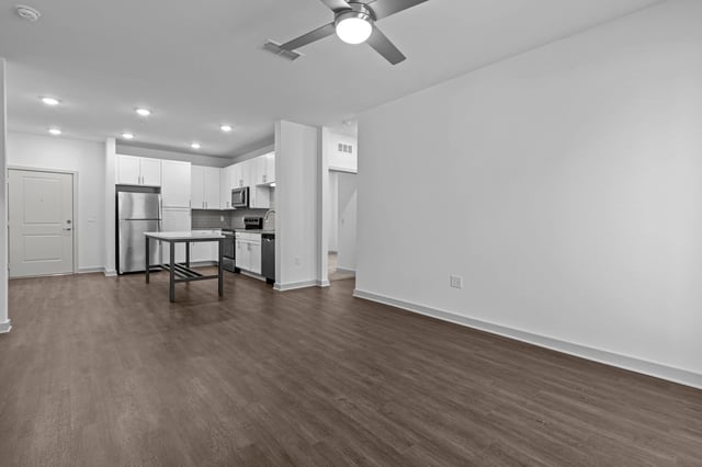 Open concept living area with a modern kitchen featuring stainless steel appliances and an island.