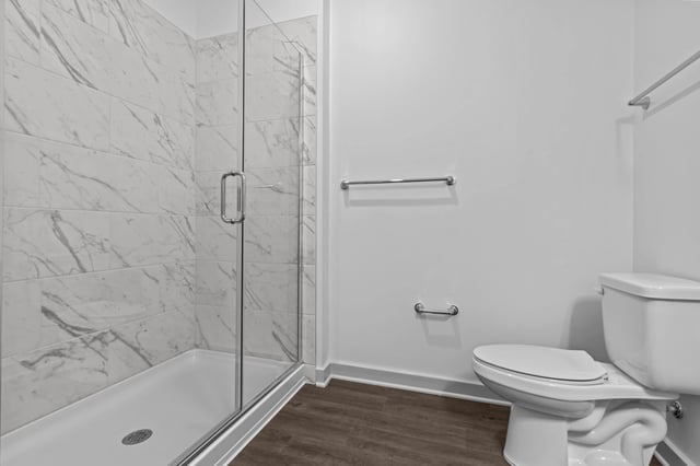 Modern bathroom with glass-enclosed shower and toilet.