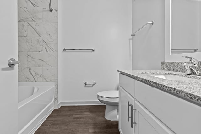 Modern bathroom with a bathtub, toilet, and vanity with granite countertops.