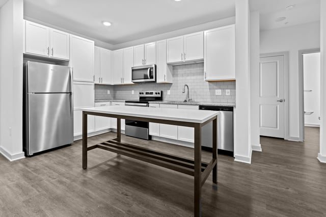 Modern kitchen with white cabinets, stainless steel appliances, and a center island.