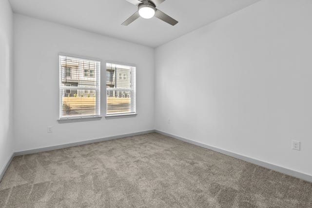 Empty bedroom with two windows and a ceiling fan.