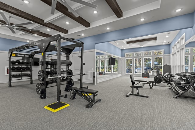 Well-equipped fitness center with weight racks, benches, treadmills, and rowing machines.