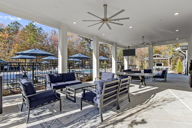 Covered outdoor patio with seating and pool view.