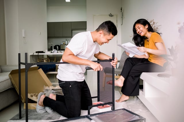 Couple assembling furniture in apartment