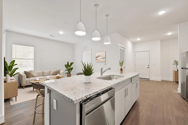 Modern open-concept kitchen with granite countertops, stainless steel appliances, and island seating.