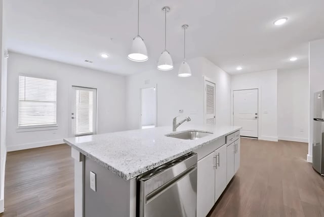 Modern kitchen island with granite countertops and stainless steel appliances.