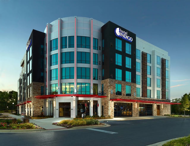 Exterior view of the Hotel Indigo building at dusk.