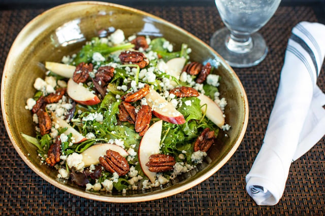 A fresh salad with apples, pecans, and blue cheese.