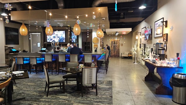Bar area and lounge with tables and chairs, decorated for a holiday event.
