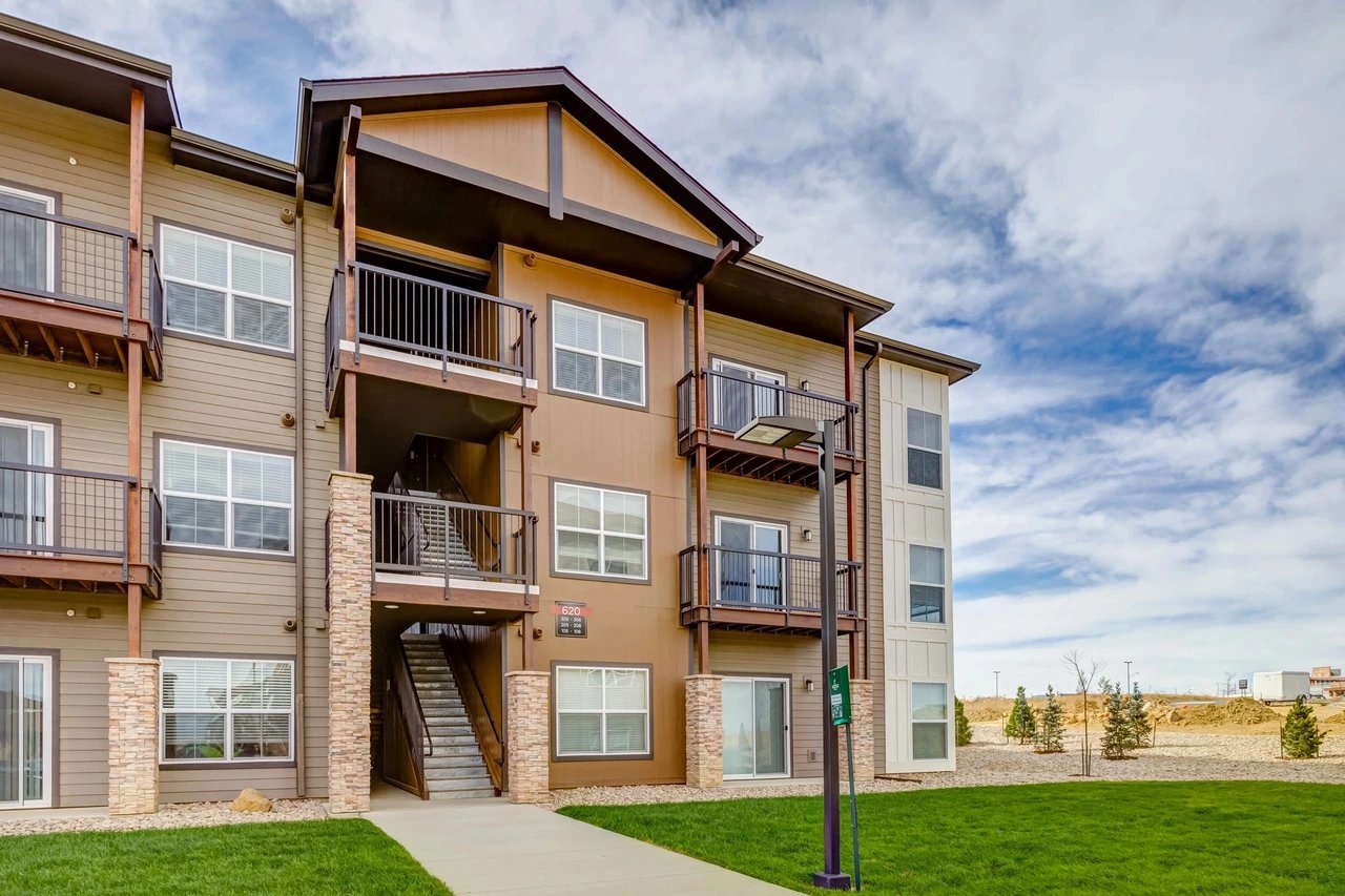Exterior of a multifamily apartment building with balconies and outdoor staircases.