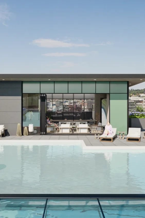 Rooftop pool with lounge chairs and a glass-walled lounge area.